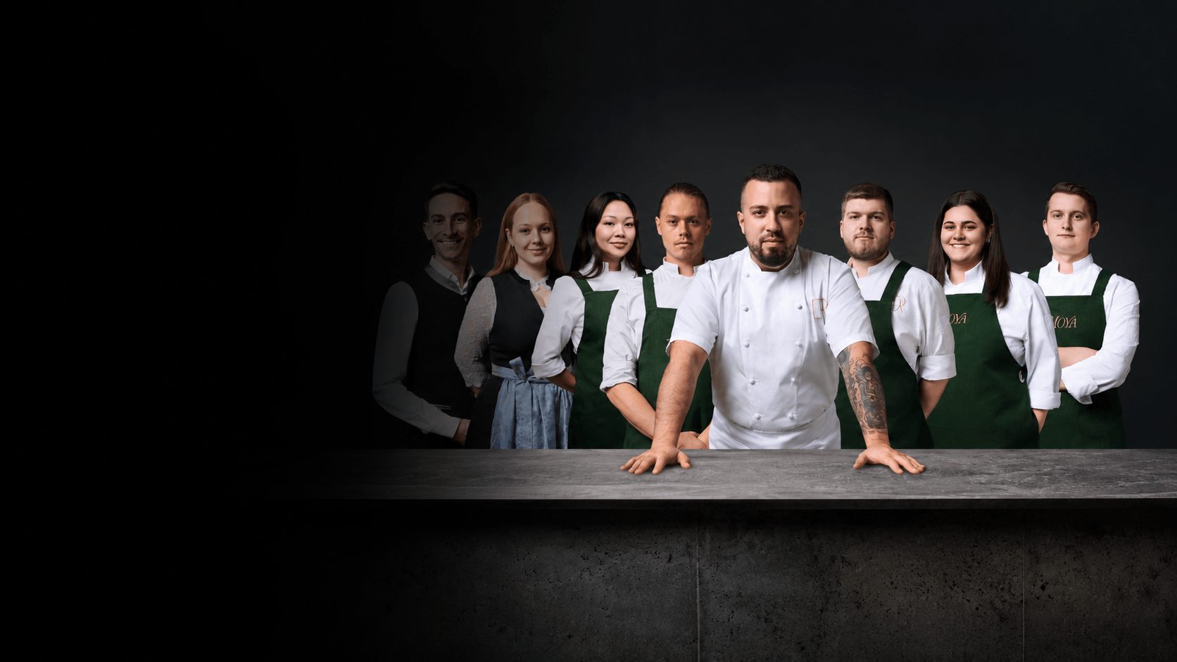 Daniel Wallenstein mit seinem Küchen- und Serviceteam hinter einer steinernen Theke.